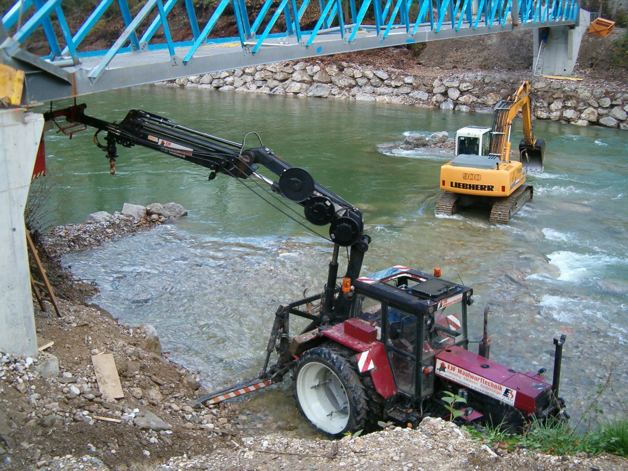 Traktor mit Kran bei Brückenarbeiten